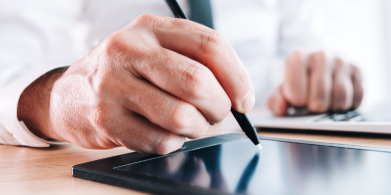 man writing his signature