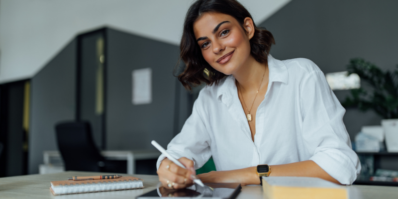 Woman on ipad smiling at camera
