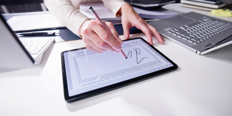 woman signing on a tablet